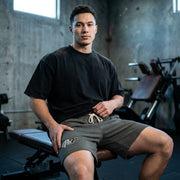 Man sitting on a weight bench in a gym setting