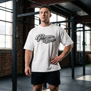 Man wearing a white t-shirt with 'Prayer and Pump' text in a gym setting